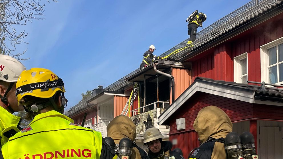 räddningspersonal på taket på en fastighet