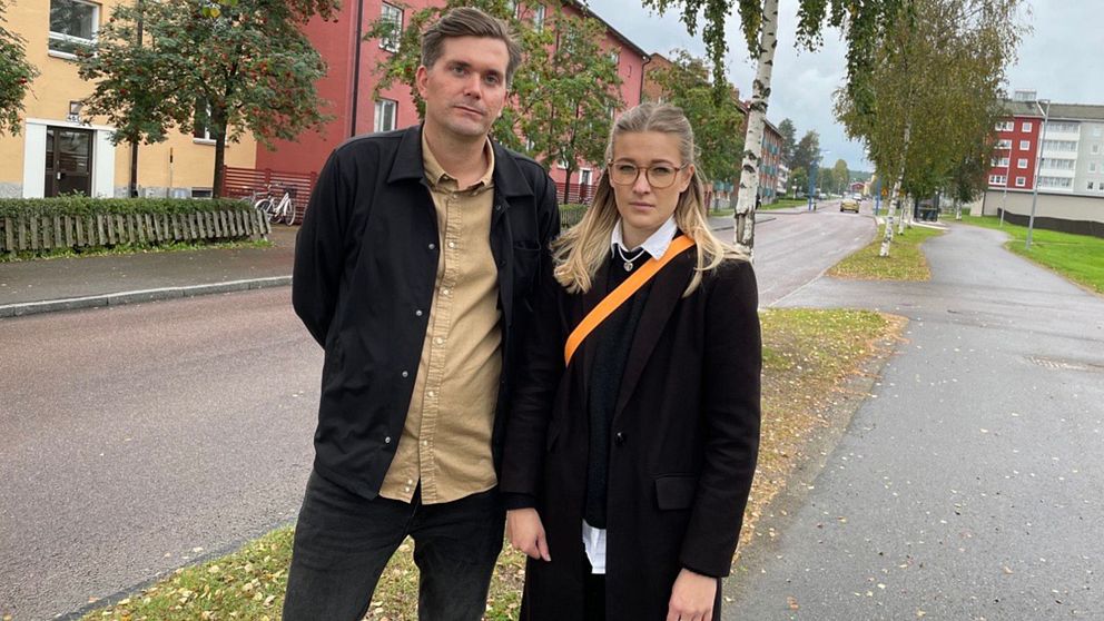 två reportrar från svt som står på en gångbana bredvid en väg