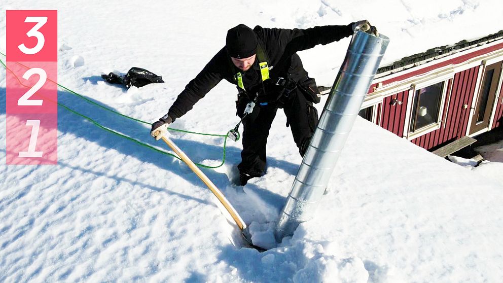 En person som mäter snö på taket