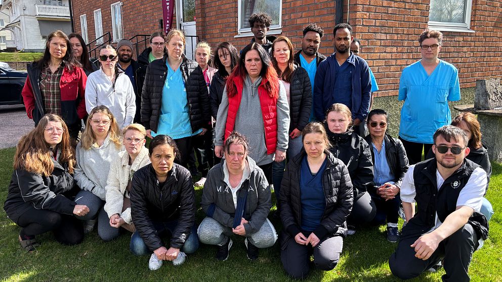 Gruppbild utomhus med vårdpersonal framför en tegelbyggnad.