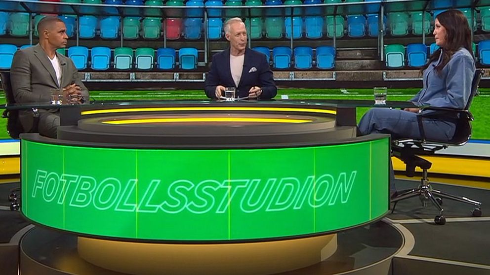 Tre personer diskuterar i en TV-studio med ”Fotbollsstudion” på bordet.