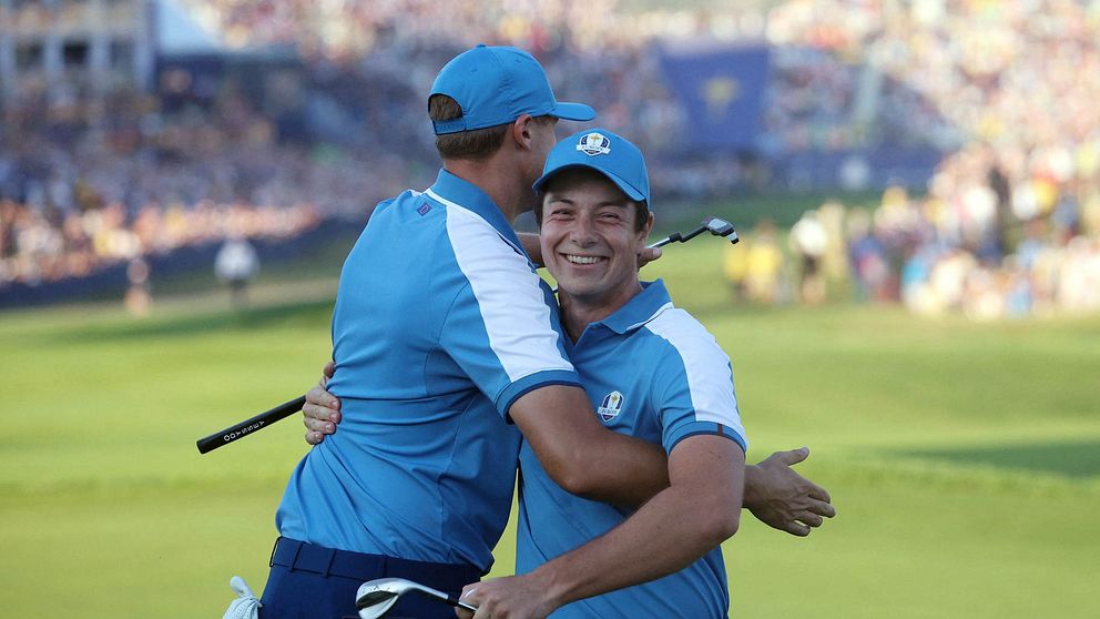 Ludvig Åberg kramar om Viktor Hovland efter att denne satt en monsterputt på det första hålet.