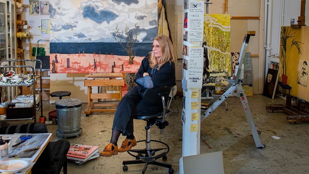 Karin Mamma Andersson sitter på en stol i sin ateljé.