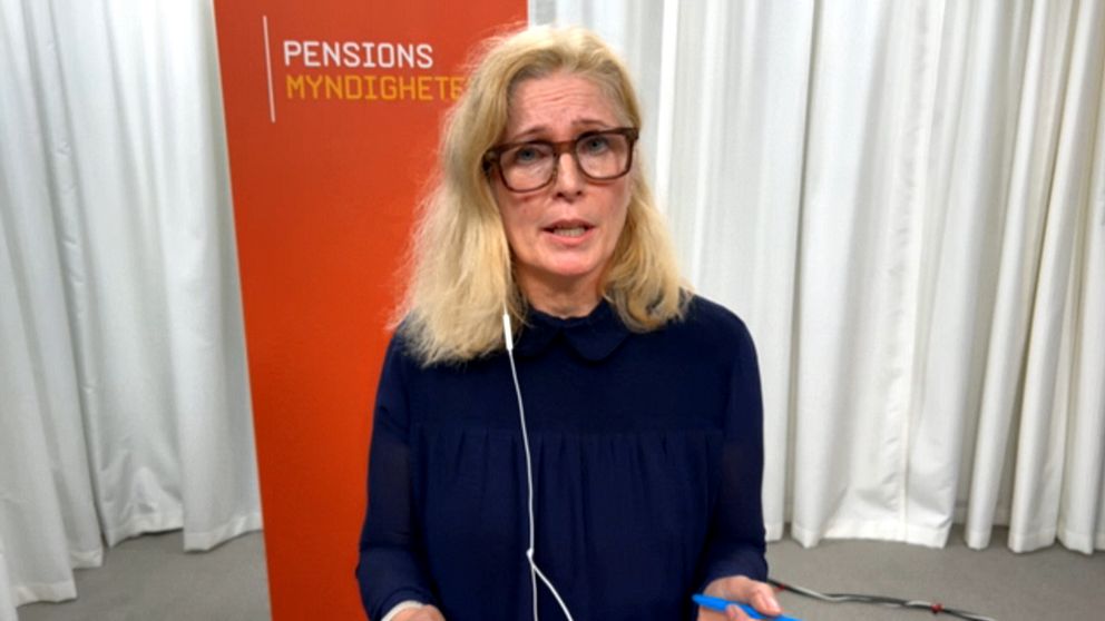 Katharina Hultberg står framför en orange bakgrund med texten ”Pensionsmyndigheten”. Hon har hörlurar på sig och håller i en penna.