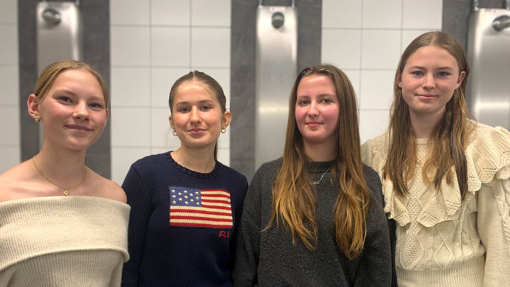 Fyra tjejer står tillsammans i duschrummet