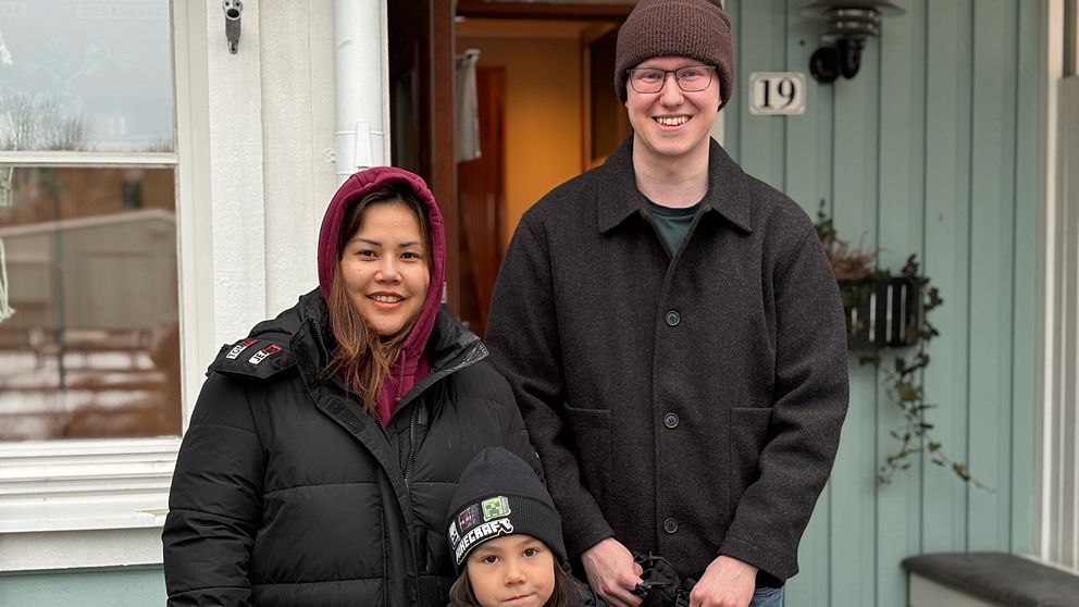 Familj står utanför hus med vinterkläder. De har varit på husvisning.