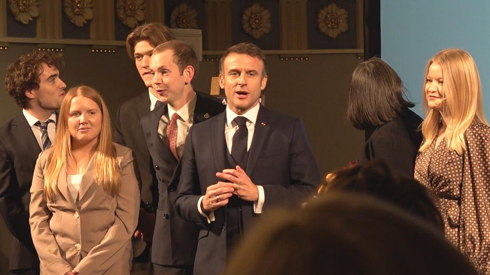 Frankrikes president Emmanuel Macron omgiven av studenter