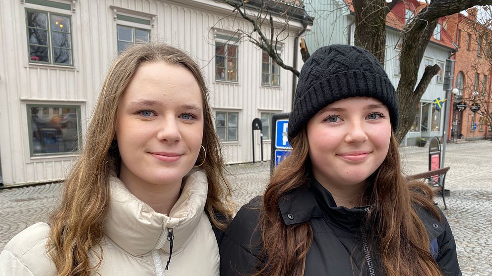 Estelle Bäckström och Emilia Björk står på torget i Mariefred. De har vinterjackor på sig och ser glada ut.