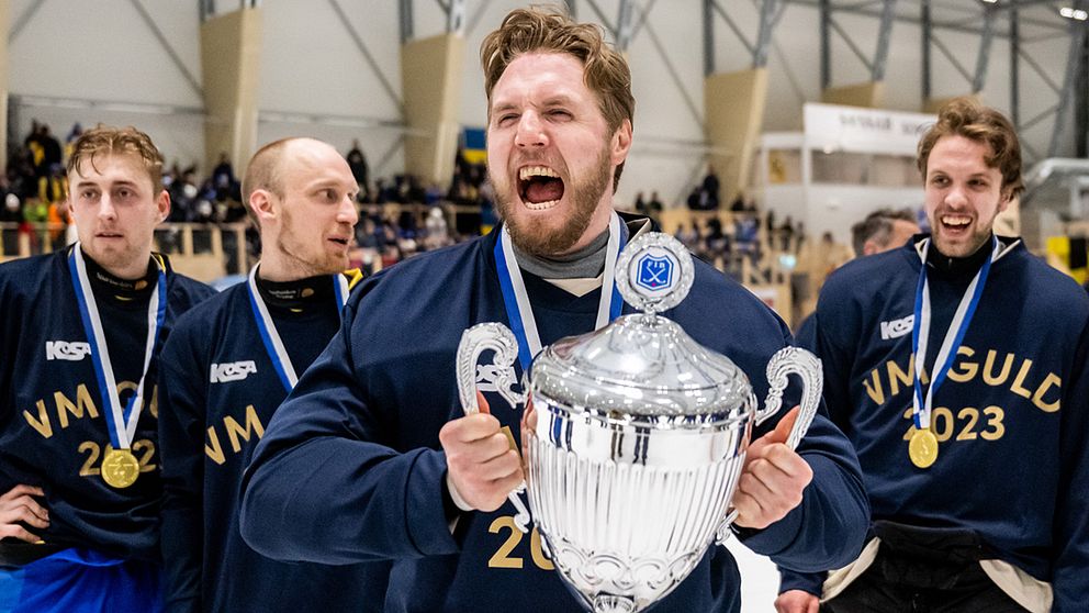 Lag i VM-tröjor firar mästerskapsvinst med pokal och medaljer.