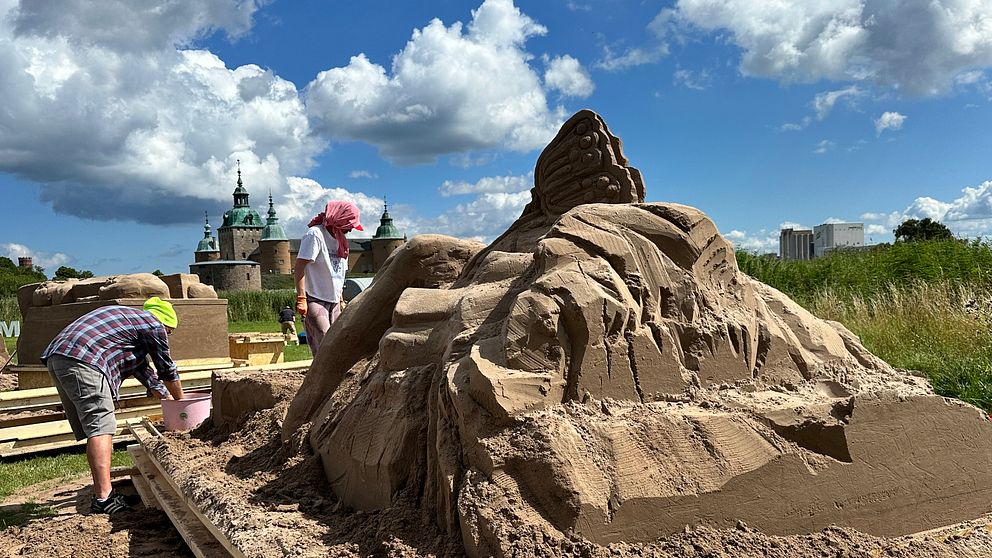 Sandskulptur börjar ta form. Skulptörer arbetar vid den