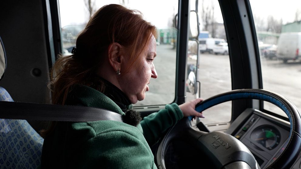 En kvinna sitter bakom ratten på en lastbil.