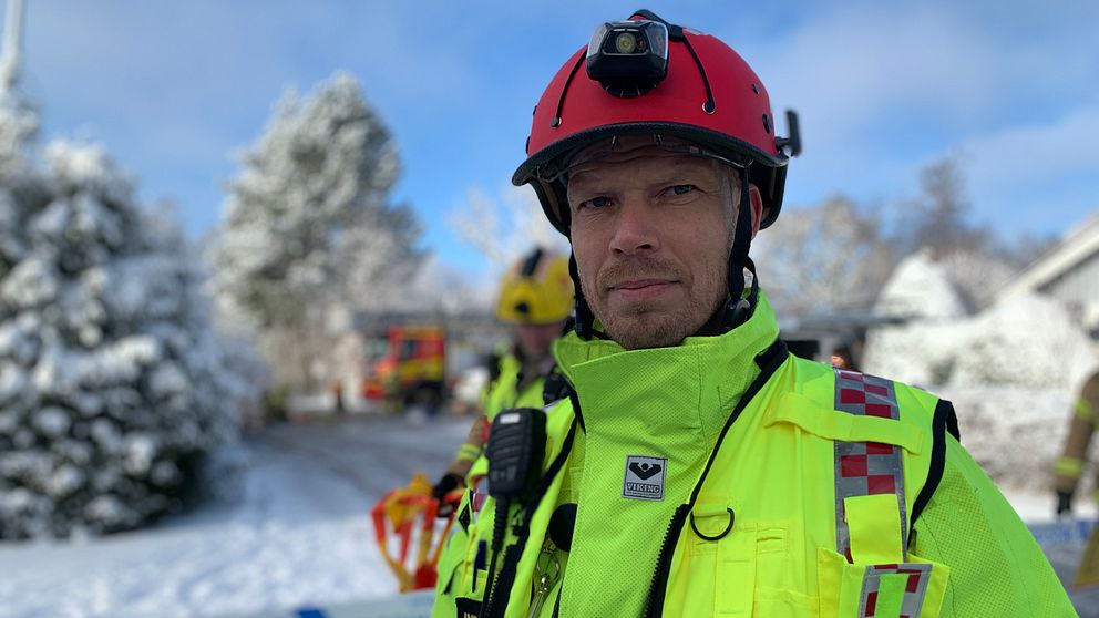 En brandman står i ett snöigt landskap.