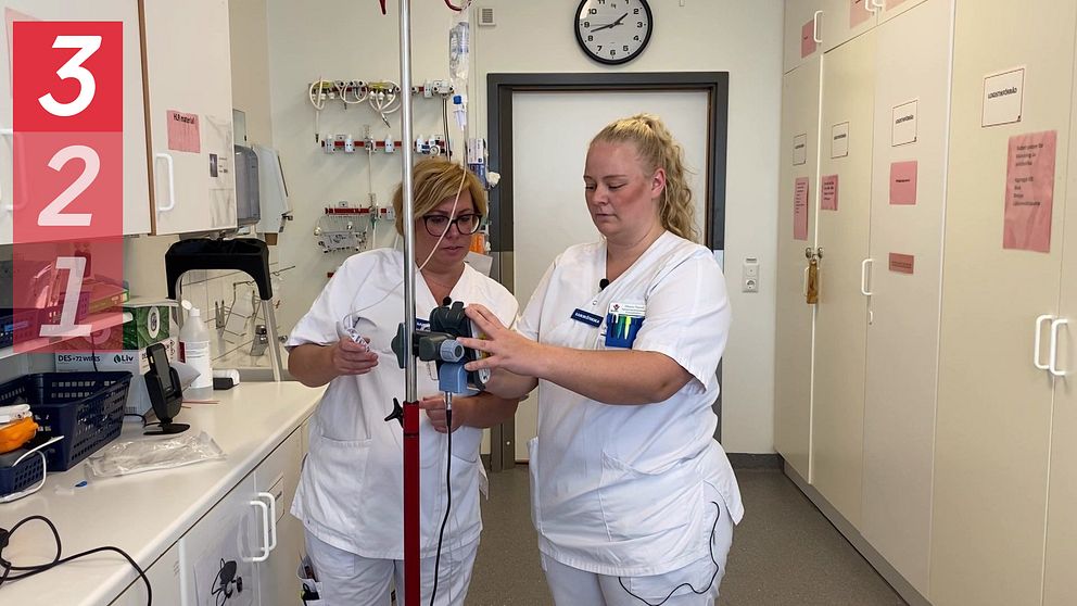 Två sjuksköterskor ställer in en droppställning på sjukhuset i Västerås.