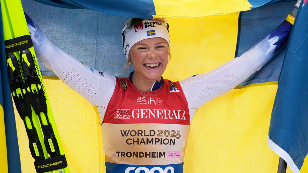 Skidåkare firar med en svensk flagga, bär guldfärgad väst med texten ”World Champion Trondheim”.