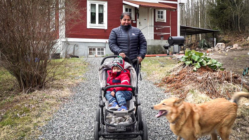 Tvåbarnsmamman Emma lämnar sitt hus med en barnvagn och en hund i Storå.