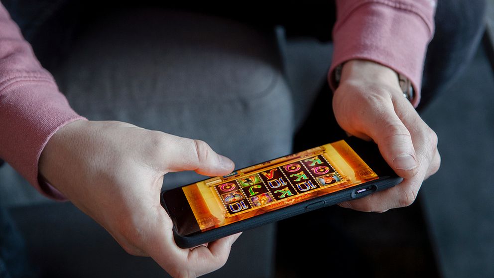 Person som spelar casinospel på en telefon.