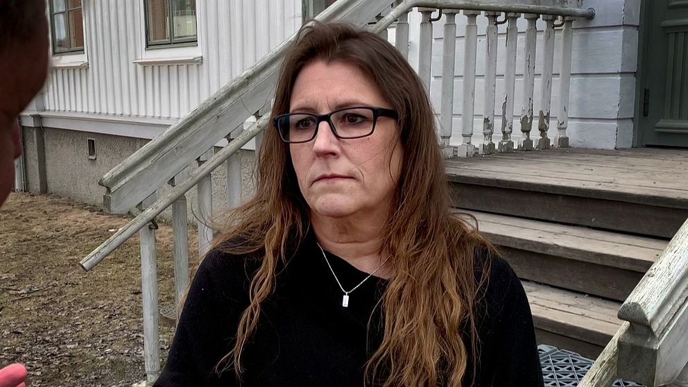 kvinna med svart tröja framför trappa.