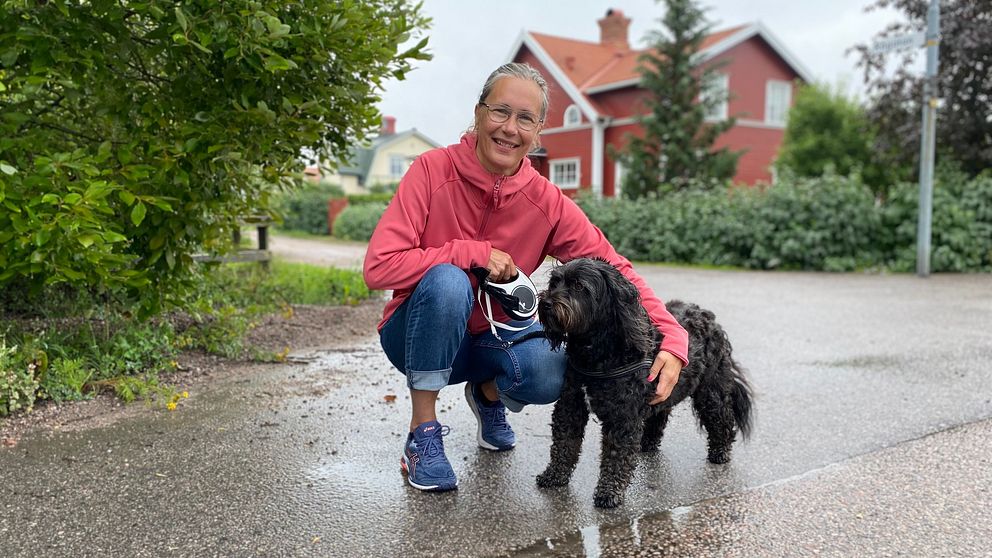 Kvinna med hund framför hus i bostadsområdet Hemsta i Gävle