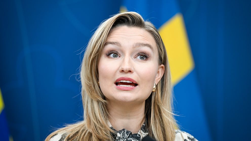Ebba Busch framför en svensk flagga.