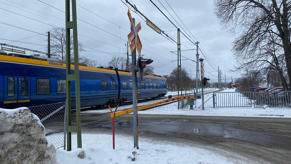 Ett passagerartåg passerar plankorsningen vid Floragatan i Sundsvall