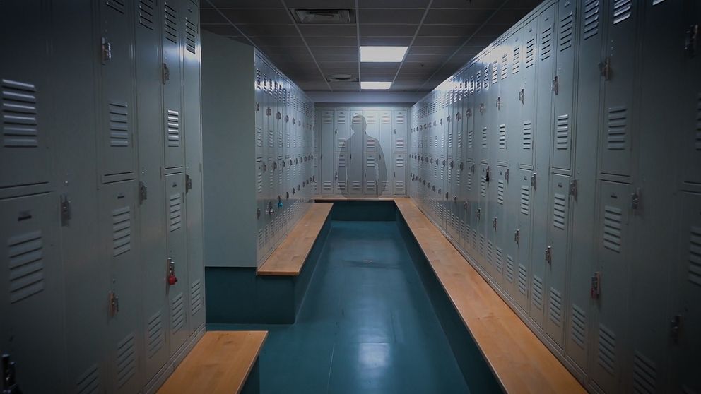 Omklädningsrum, i bakgrunden syns en svagt synlig silhuett av en person.