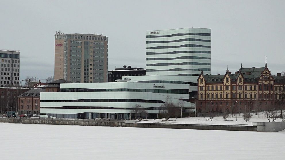 Vy över Umeälven mot kulturhuset Väven med flera byggnader, och del av Rådhusparken