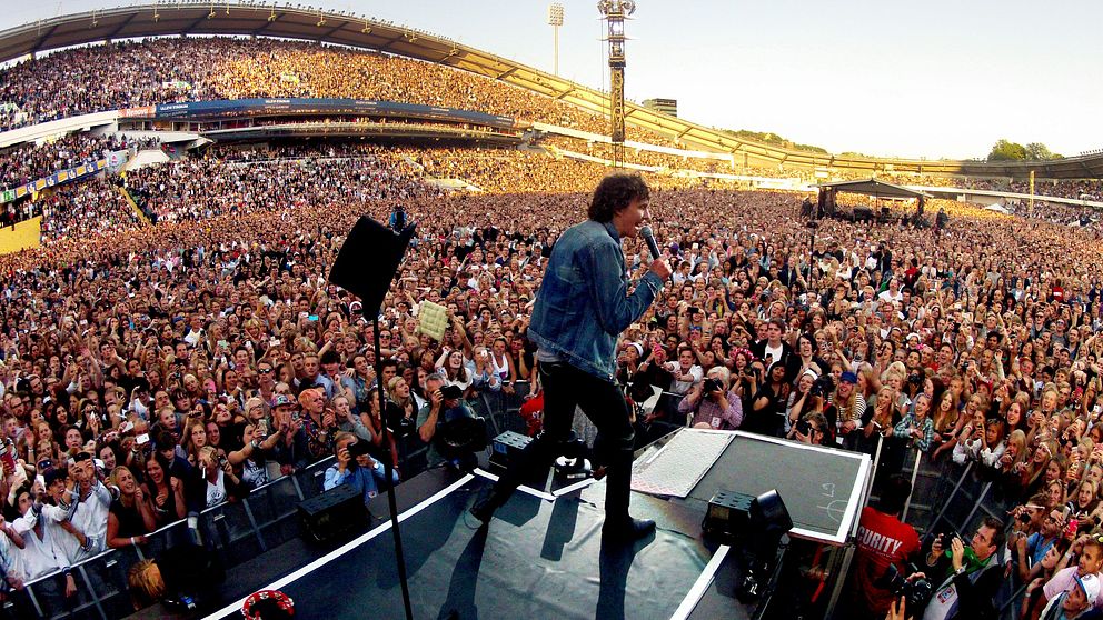 Håkan Hellström står på scenpodiet på Nya UIlevi i Göteborg. Hela arenan är full med publik,