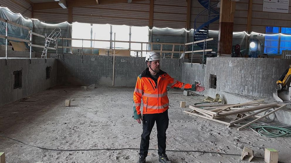 på bilden syns Per Lundmark, platschef för Peab, när han står i bassängen som renoveras på Torsbybadet.