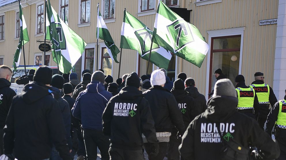 Demonstranter med gröna flaggor marscherar på en gata.