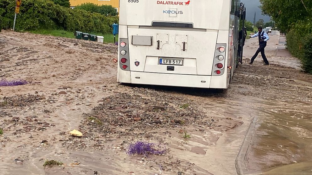 En buss sitter fast i slammassorna efter det hårda regnet i Rättvik.