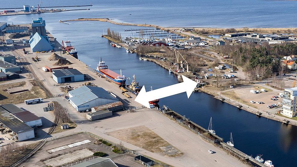 Flygbild över en hamnen och Nissans utlopp i Halmstad med en vit pil som visar vara den nya Söderbron ska byggas.