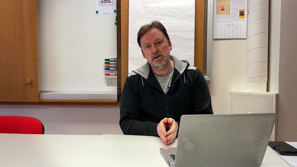 Person vid skrivbord framför laptop, i ett kontorsrum med whiteboard och anslag på väggen.