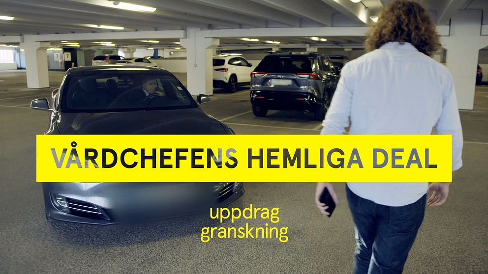Man i blå skjorta och grå bil