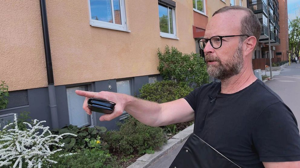 Renoveringraseriets ordförande, Alfred Skogberg, pekar ut en byggnad i centrala Karlstad där han ser att tidstypiska byggnadsdetaljer har förvanskats.