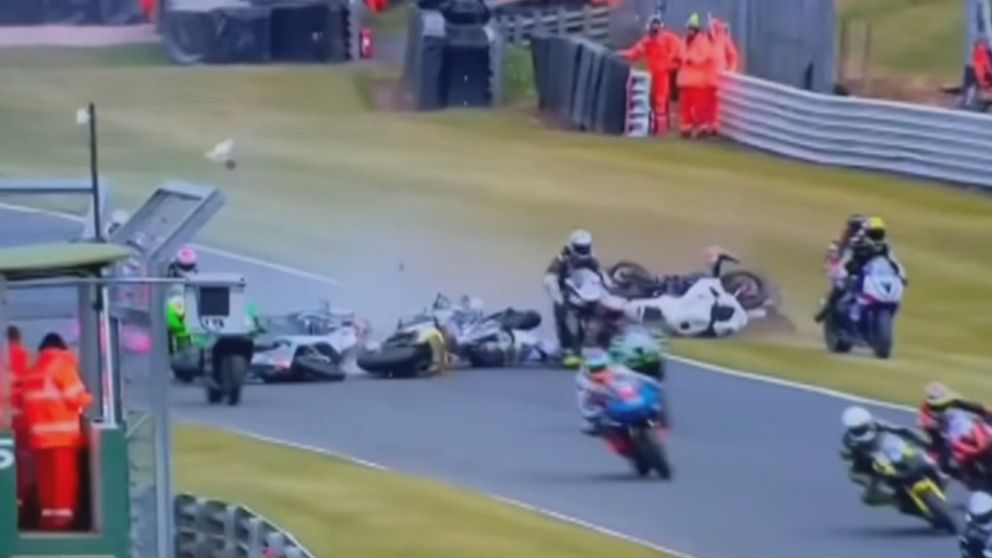 Flera motorcyklar har kraschat på en racerbana medan funktionärer rycker ut.