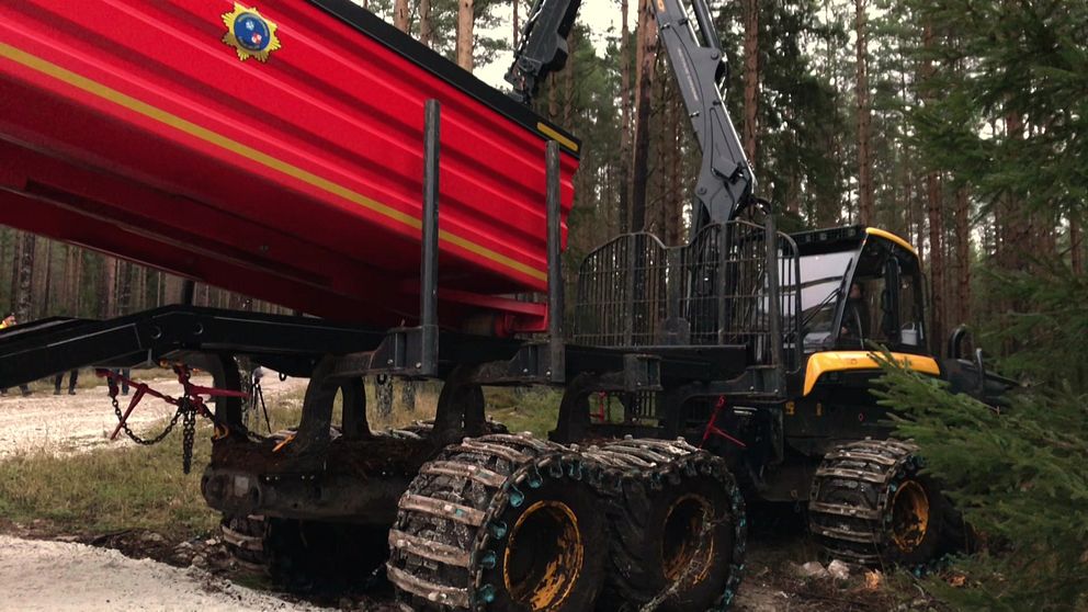 En skogsmaskin med räddningstjänstens vattentank på.