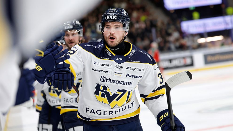 Ishockeyspelare från HV71 firar på isen under en match med lagkamrater.
