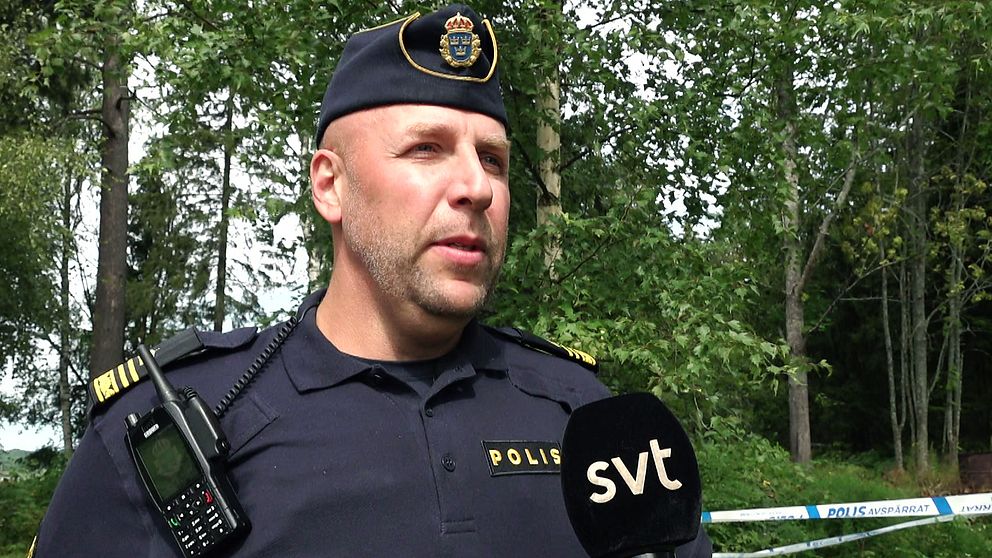 Morgan Olsson, gruppchef för lokalpolisområde Torsby intervjuas framför avspärrningsband efter ett misstänkt mordförsök utanför Sunne.