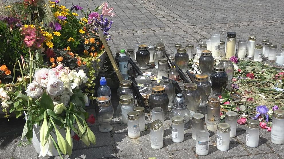 Blommor och ljus vid minnesplatsen i Tollarp.