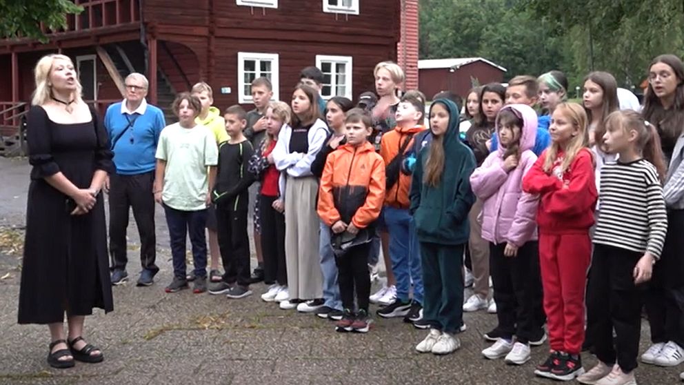 Barn med handen på hjärtat sjunger ukrainska nationalsången