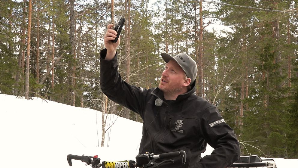 Thomas Ahlm från Naggen håller upp mobiltelefonen i luften för att se om han har mobiltäckning.