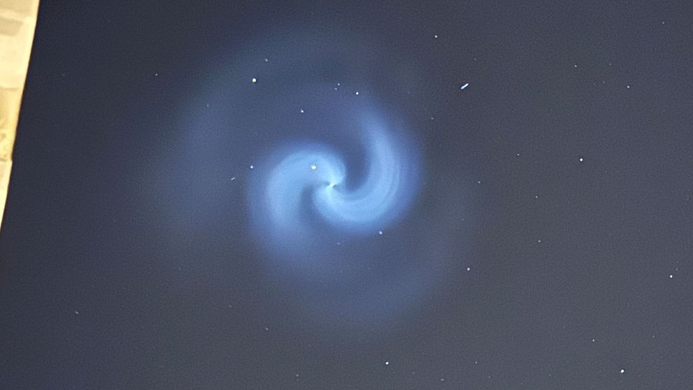 Stjärnhimmel med blå spiralformad ljusformation i centrum.