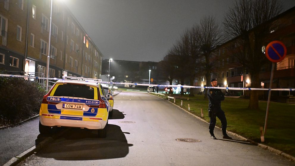 Polisbil och avspärrning vid bostadsområde på kvällen.