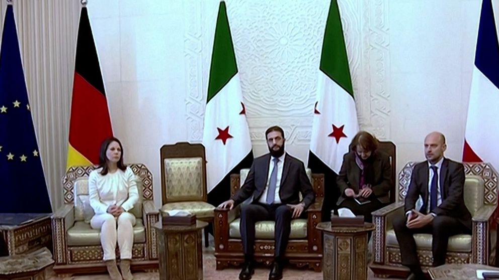 Möte mellan Tysklands utrikesminister Annalena  Baerbock, Frankrikes utrikesminister Jean-Noël Barrot och Syriens nya ledare Ahmed al-Sharaa i Damaskus. De sitter framför flera flaggor.