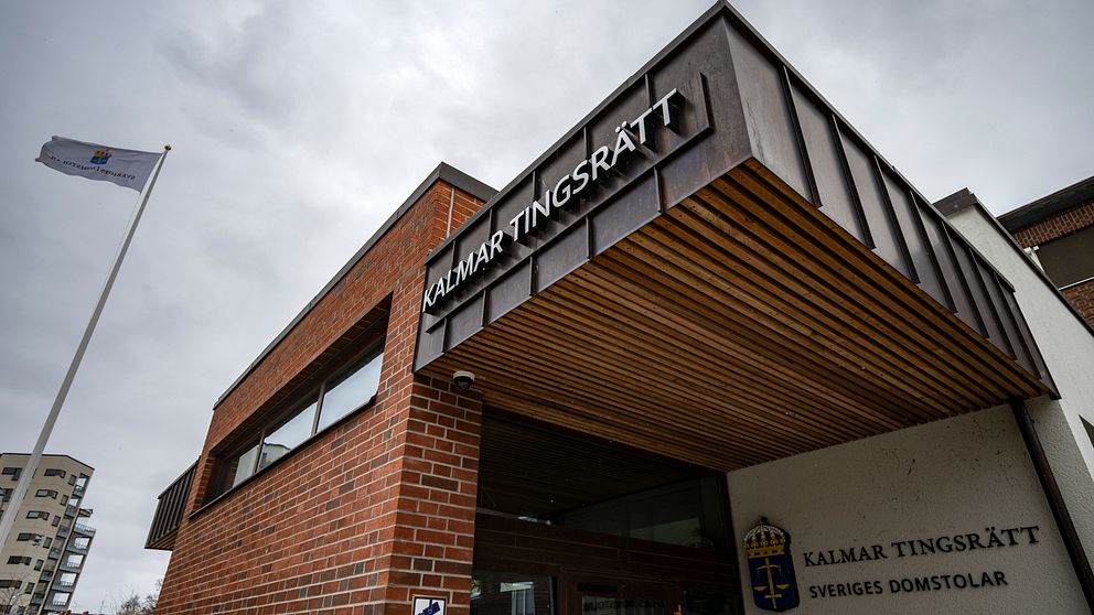 Kalmar tingsrätts byggnad, med en skylt längst upp till höger som tydligt visar namnet ”Kalmar Tingsrätt”. En flagga vajar på en flaggstång till vänster.