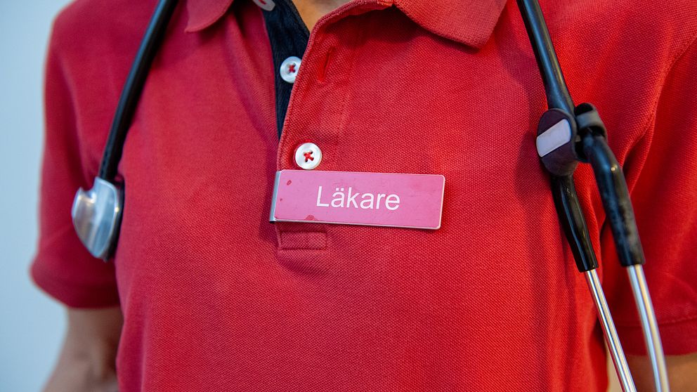 Stetoskop och en namnskylt där det står Läkare på en kvinna.