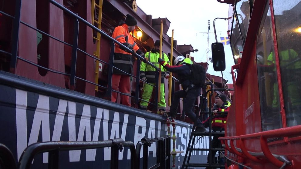Lotsen i skyddskläder tajmar vågtopparna innan hon tar klivet över vattnet och bordar skeppet som hon ska hjälpa iland.