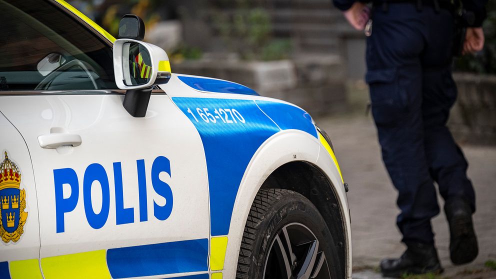 En polisbil och en polis.