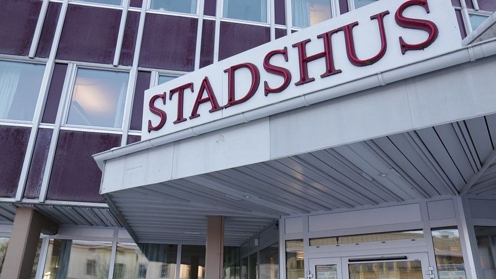 Entré till stadshus med skylt i stora röda bokstäver.