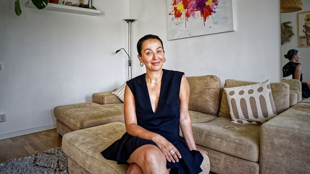 Kvinna som sitter i soffa i vardagsrum